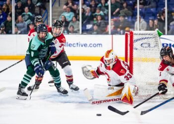 Gwyneth Philips watches the puck as Jincy Roese and Sophie Shirley battle in front of her crease - Photo @ PWHL