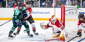 Gwyneth Philips watches the puck as Jincy Roese and Sophie Shirley battle in front of her crease - Photo @ PWHL