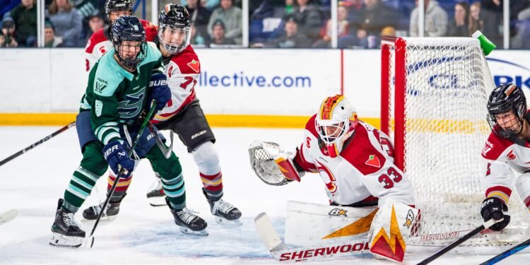 Gwyneth Philips watches the puck as Jincy Roese and Sophie Shirley battle in front of her crease - Photo @ PWHL